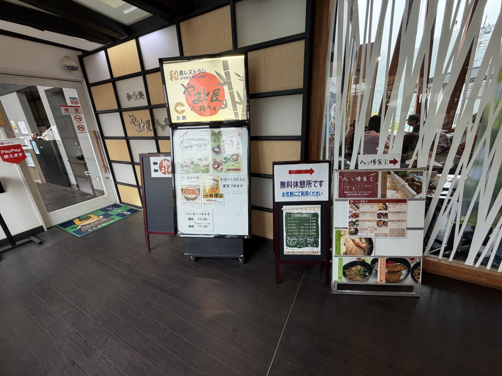 館内の案内。やまと屋八ッ場本店の営業時間と、無料休憩所、PayPayの掲示