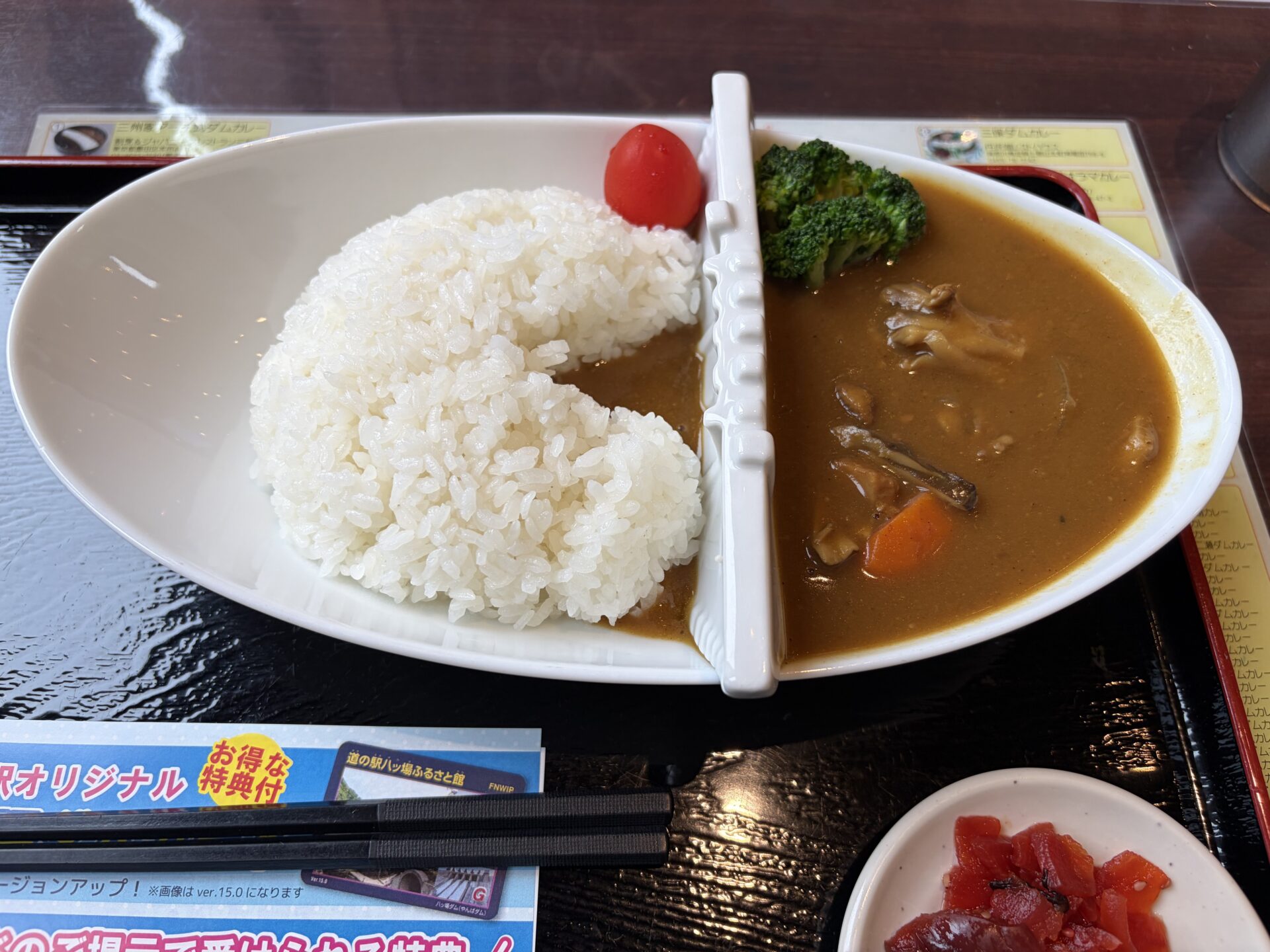 ダムカレーの寄り。カレーに舞茸と野菜、堤の脇に付け合わせ