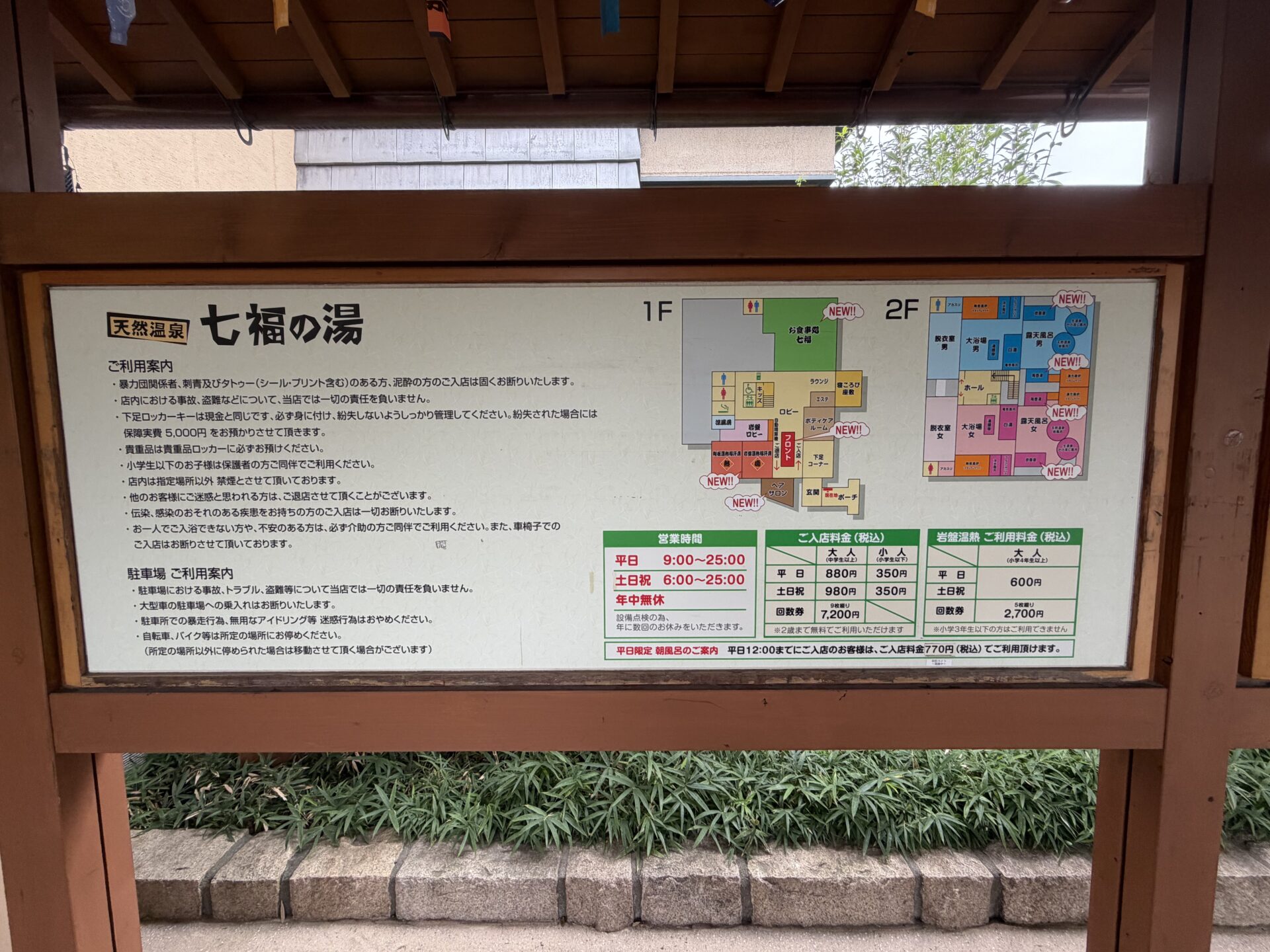 屋外の案内板。営業時間・料金・館内図・平日限定の朝風呂料金770円の案内