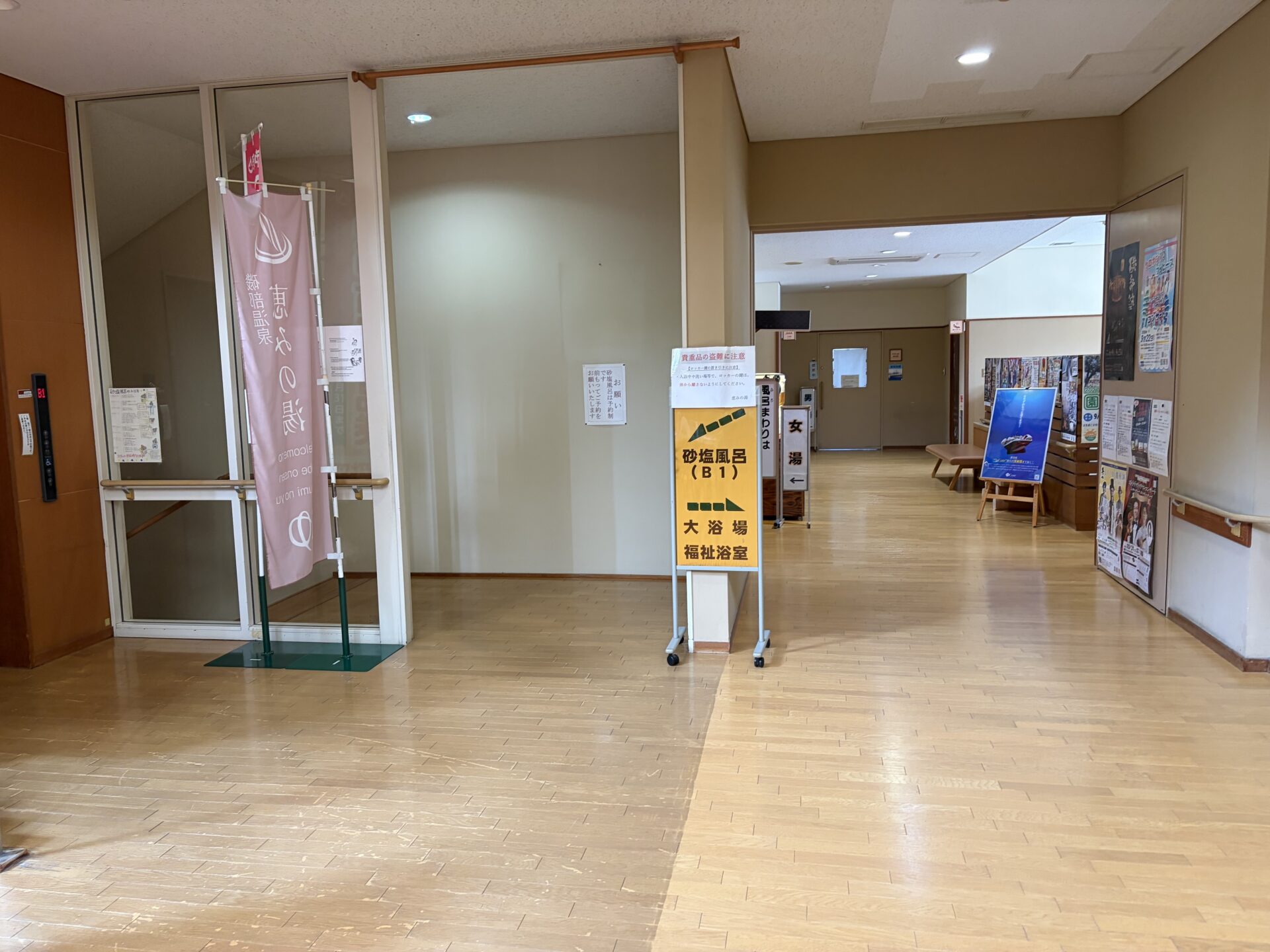 ロビーの案内看板。砂塩風呂は地下1階、大浴場と福祉浴室は1階。左の張り紙「砂塩風呂は予約制です」