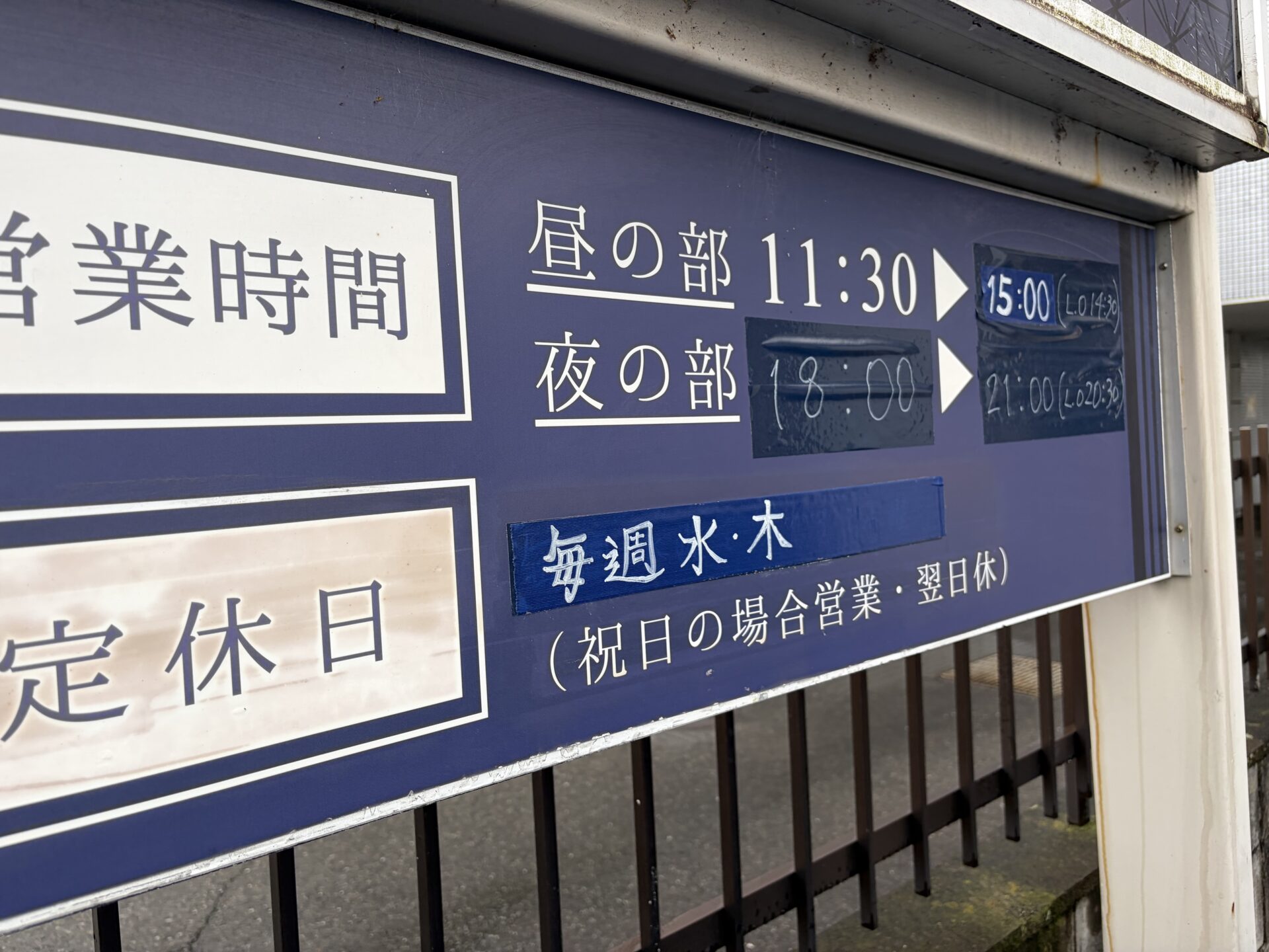 店頭の営業時間と定休日の掲示。定休日は毎週水・木（祝日の場合は営業、翌日休）