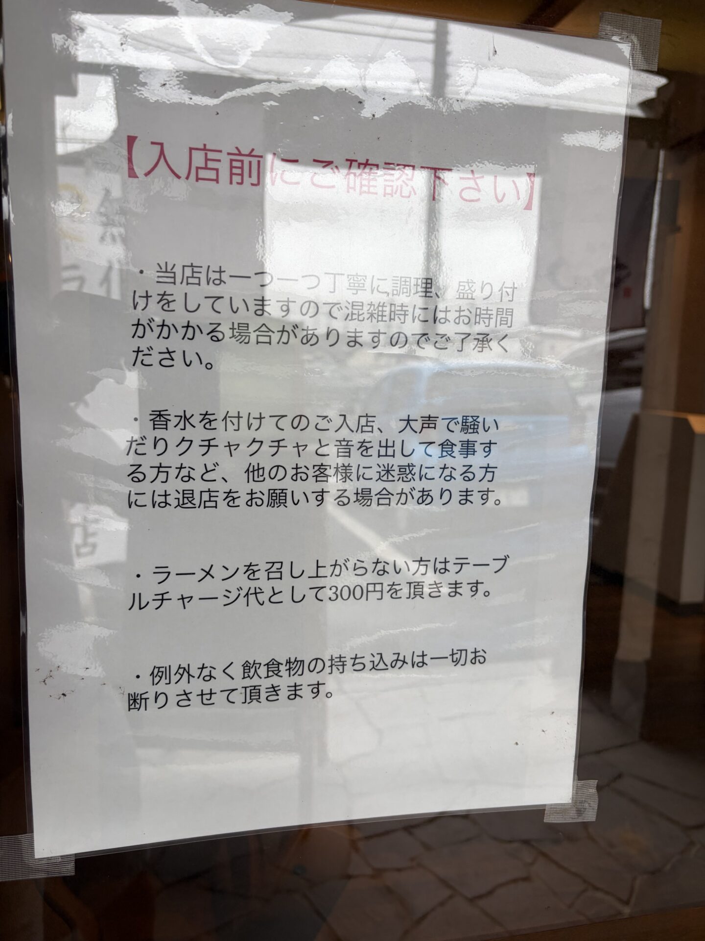 入口の掲示「入店前にご確認下さい」。テーブルチャージ・持ち込み不可などのルール