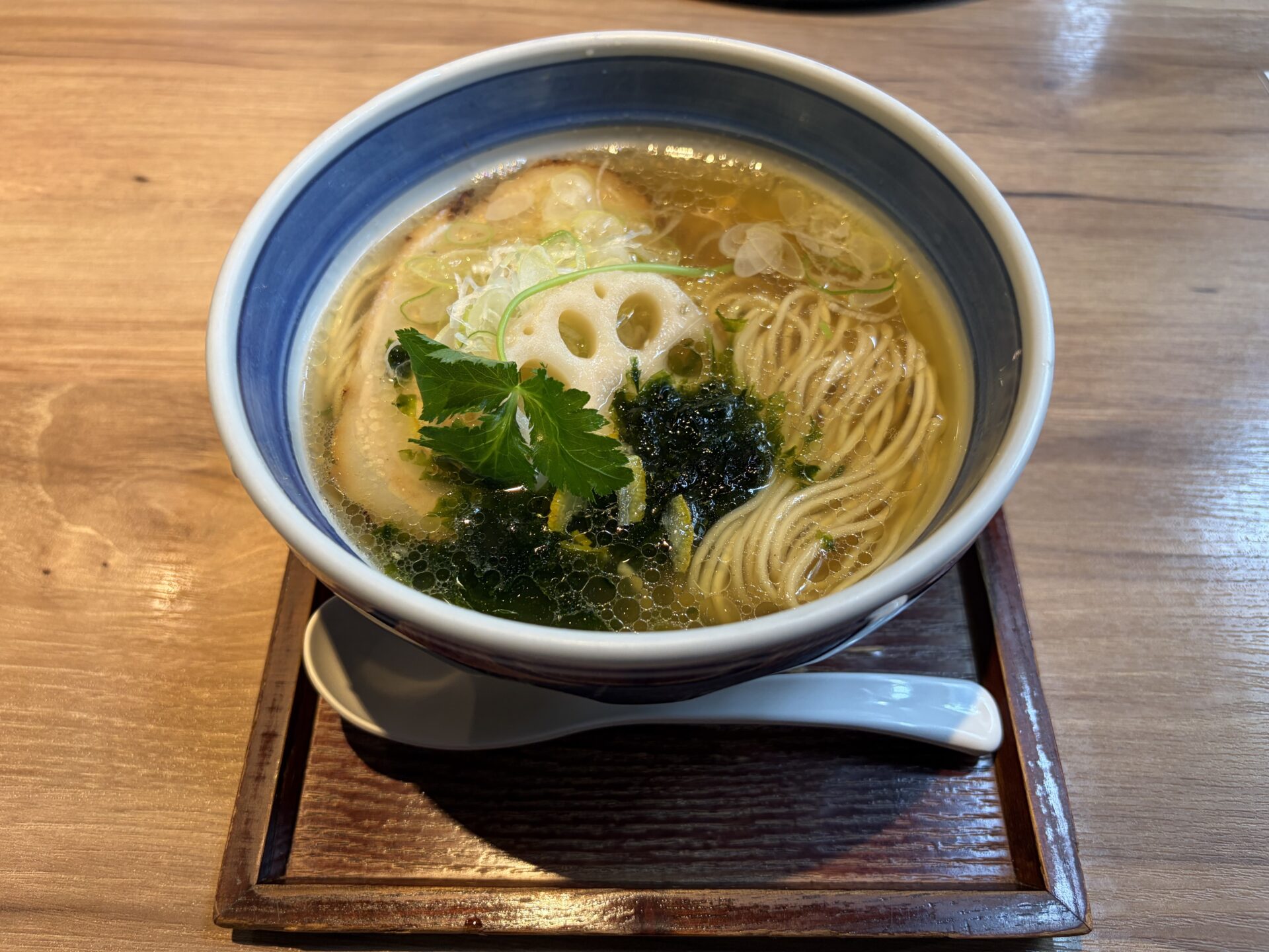 特製塩らーめん。澄んだ黄金色のスープに蓮根、三つ葉、生のり、チャーシュー、柚子