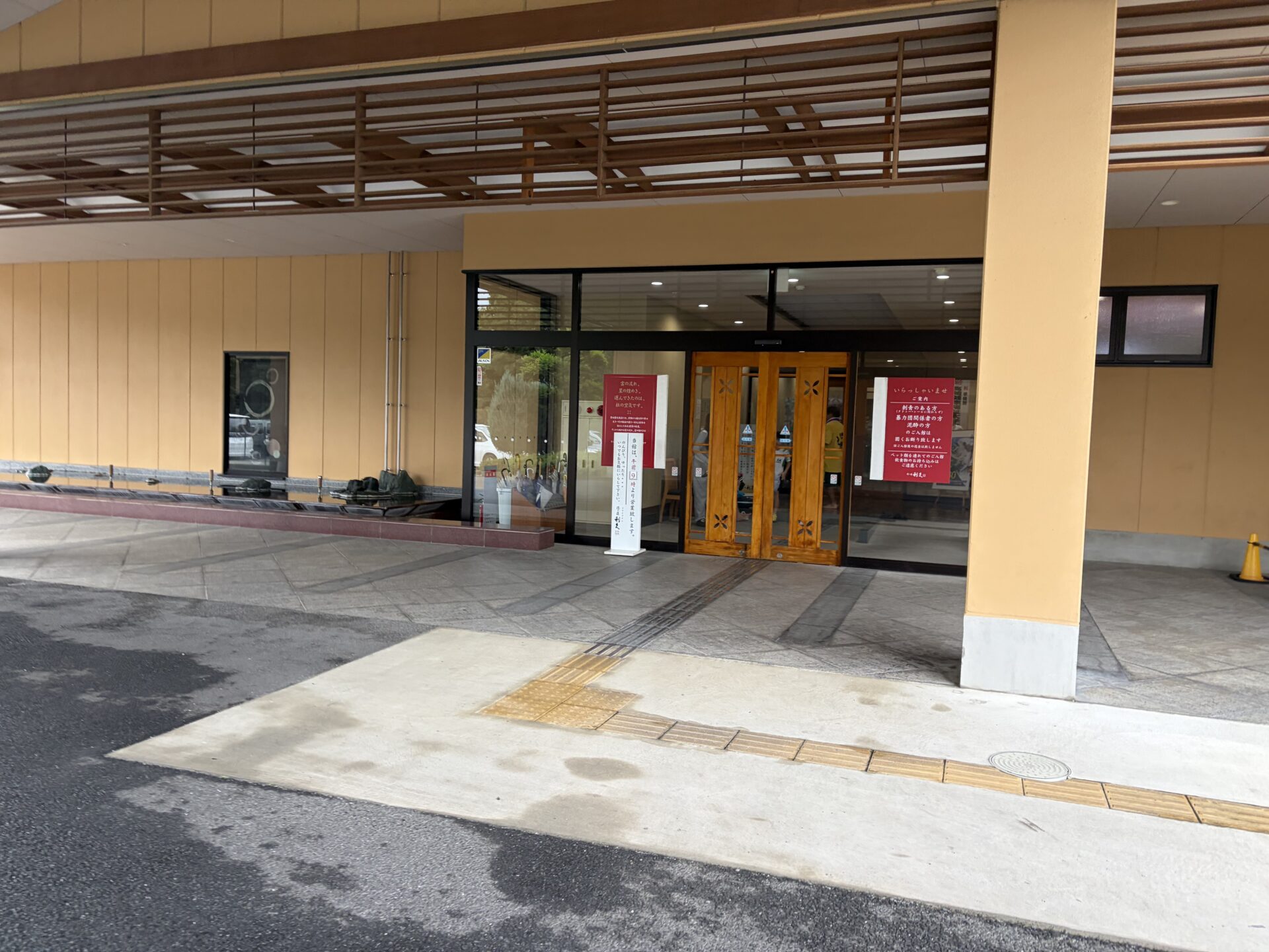 車寄せの屋根と朱色の自動ドア。湯の道利久 前橋南インター店の玄関