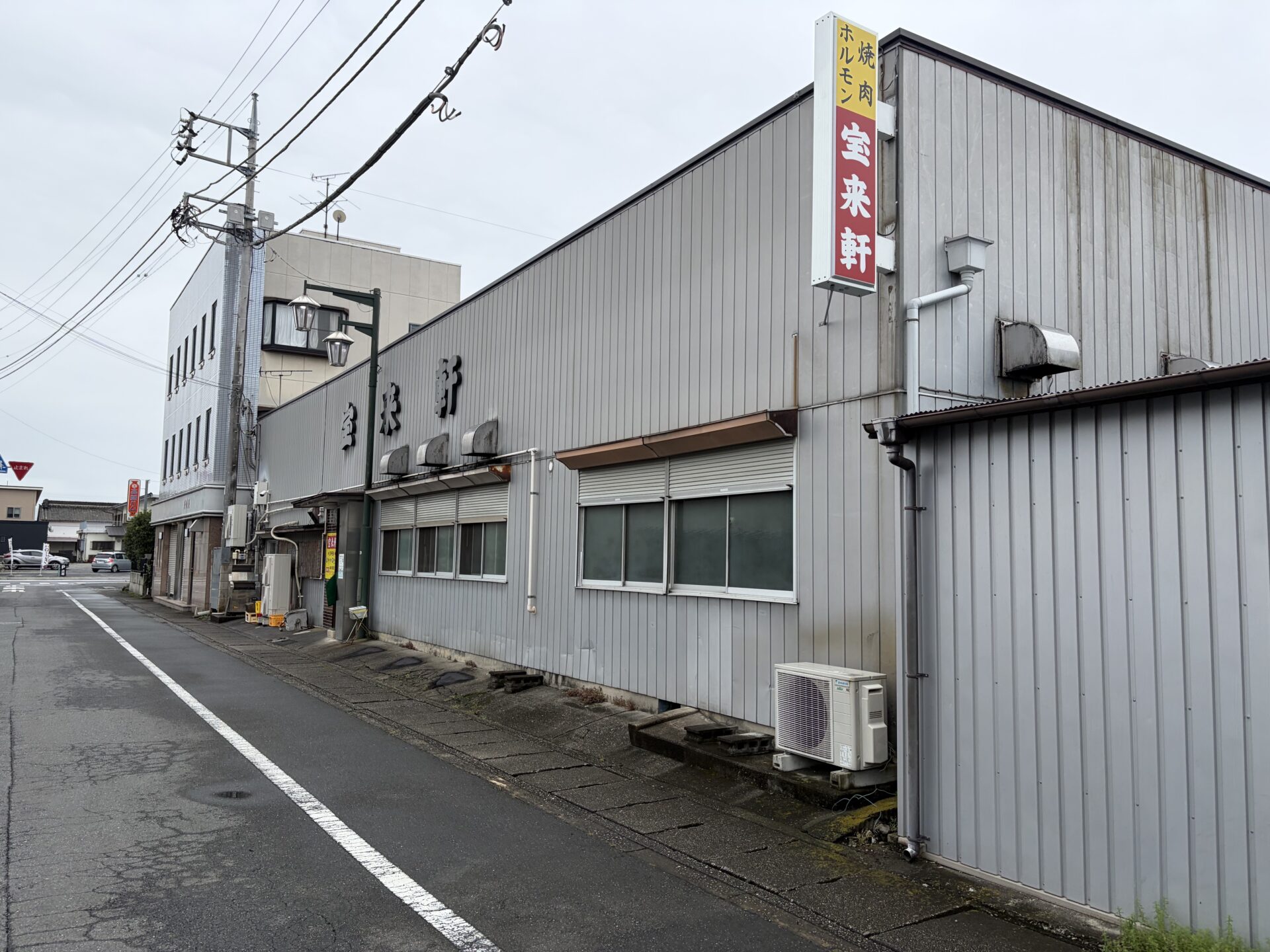 通り沿いの外観。縦看板に「焼肉 ホルモン 宝来軒」