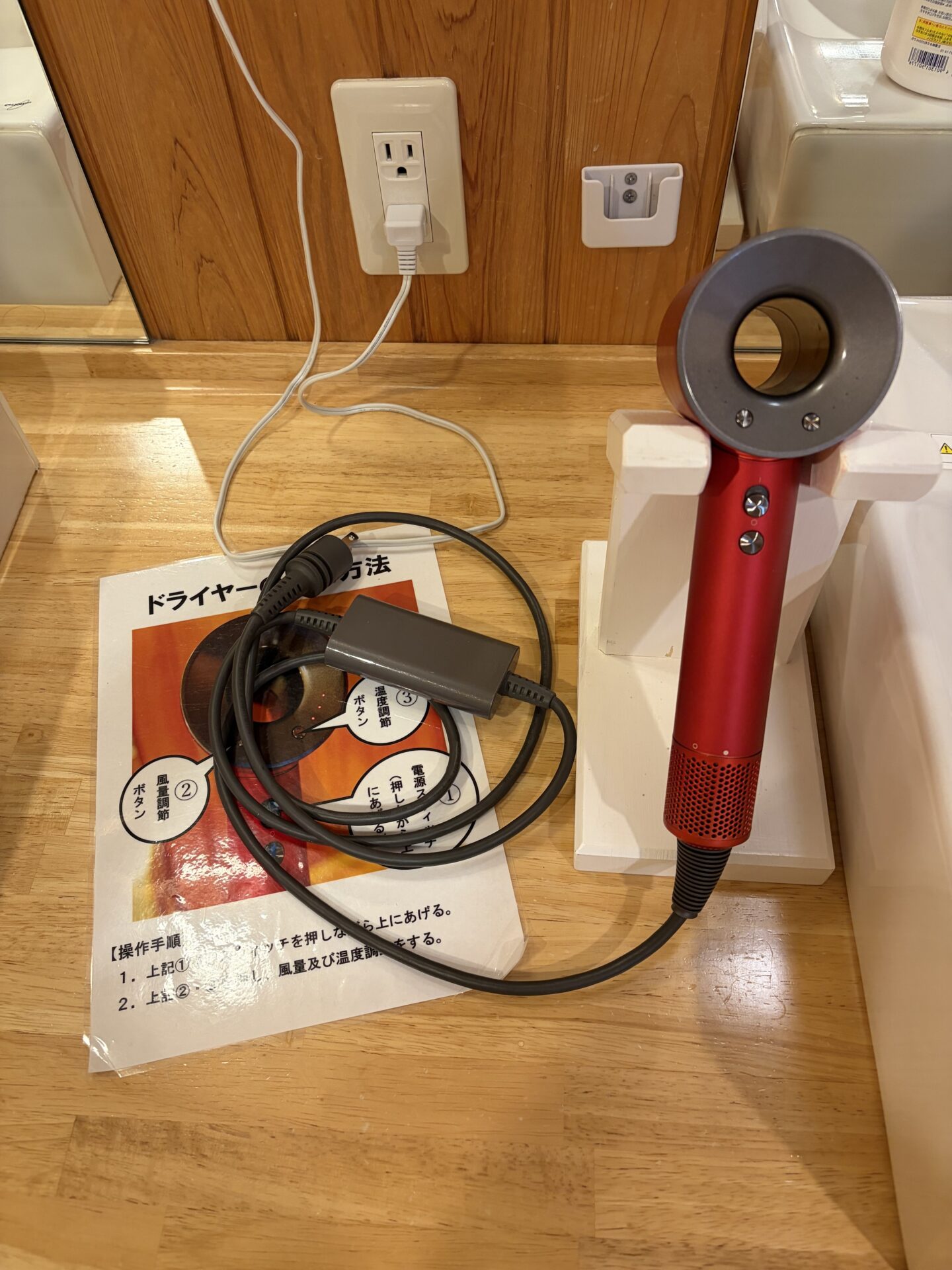 家族風呂のドライヤー。ダイソン型で、操作説明の紙が添えてある