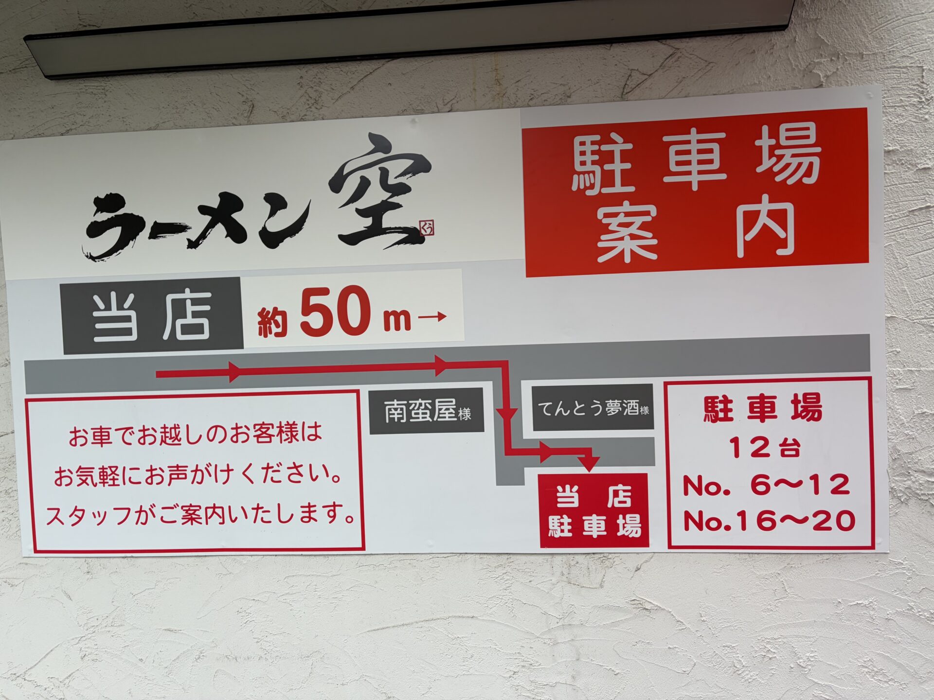 店の外壁の駐車場案内。「当店 約50m→」、南蛮屋とてんとう夢酒の奥に当店駐車場、12台 No.6〜12・No.16〜20