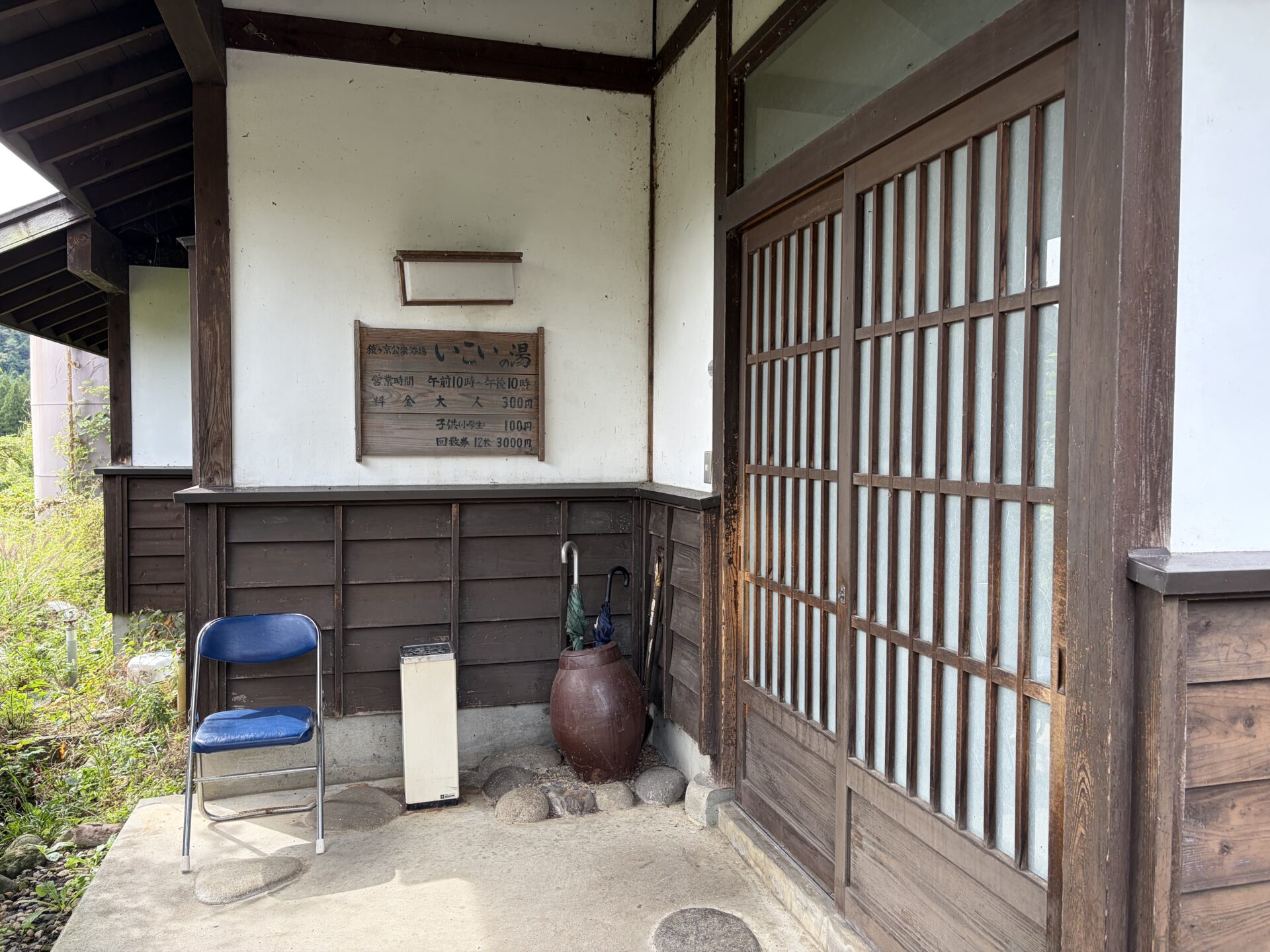 玄関脇の木の看板。営業時間 午前10時〜午後10時、大人300円、子供（小学生）100円、回数券12枚3,000円