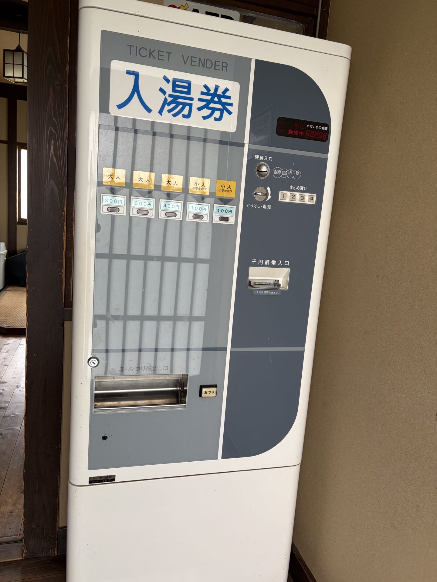 入湯券の券売機。大人300円と小人100円のボタン、千円札の投入口