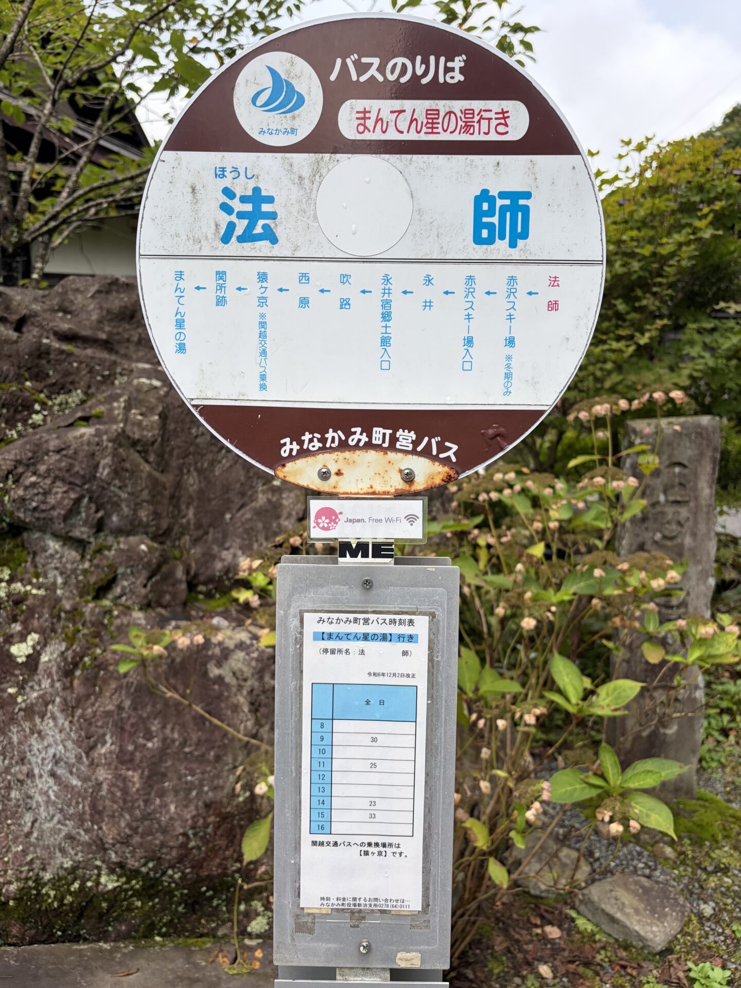 町営バスのバス停「法師」。まんてん星の湯行きの時刻表が貼られている