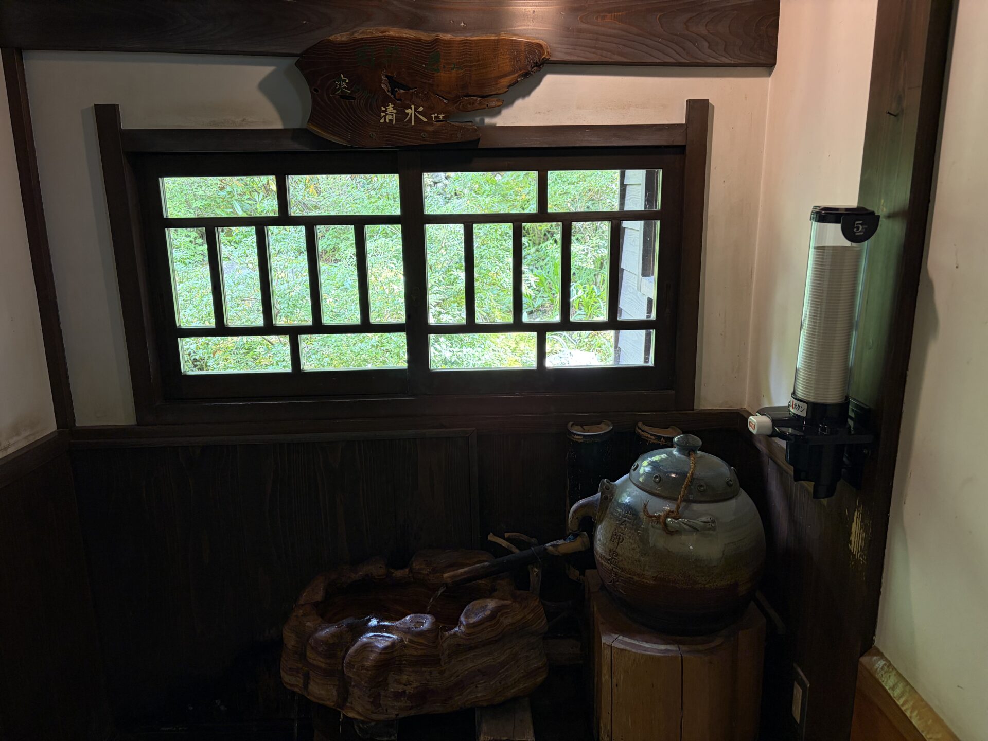 館内の水飲み場。「自然の恵み……清水です」の札と、「法師温泉」と書かれた壺、紙コップ