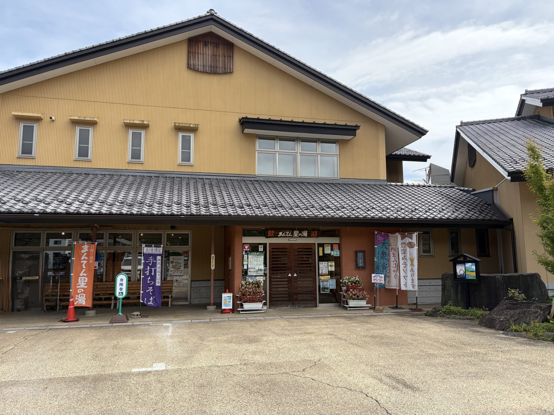正面入口。「日帰り温泉 まんてん星の湯」と「土・日限定 地元平成そば会 手打ちそば」ののぼり