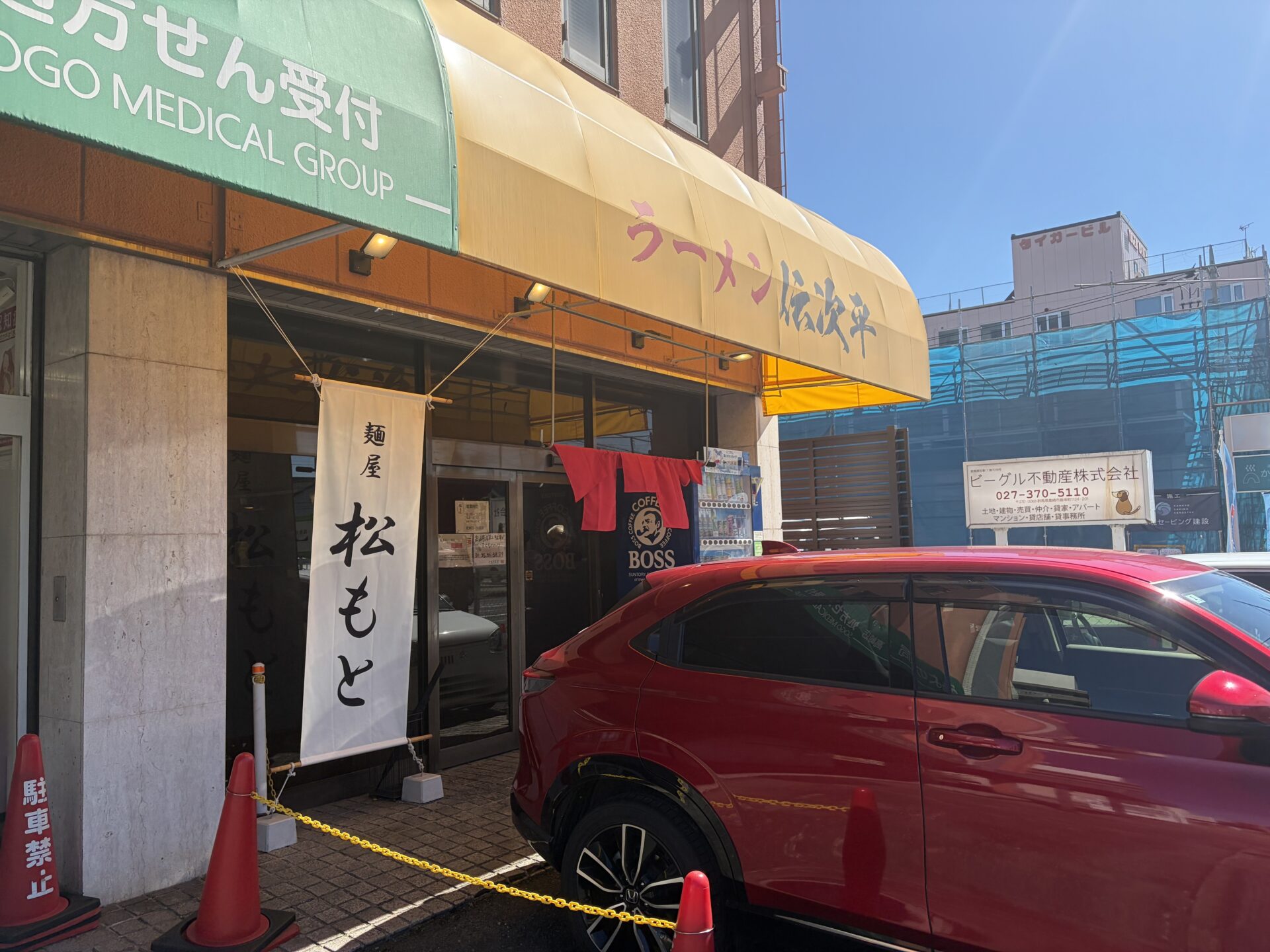 店の入口。のれん「麺屋 松もと」と、黄色い庇に残る前の店の名前