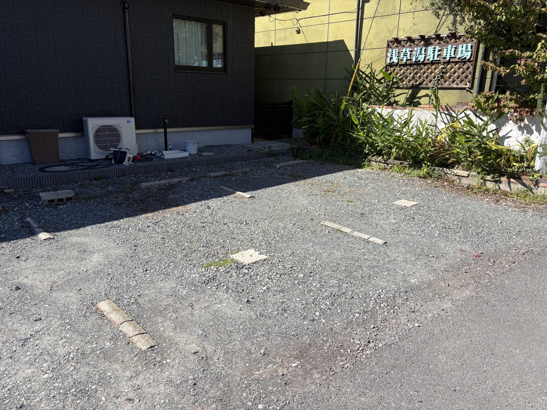 北側の駐車場。奥の壁に「浅草湯駐車場」の看板