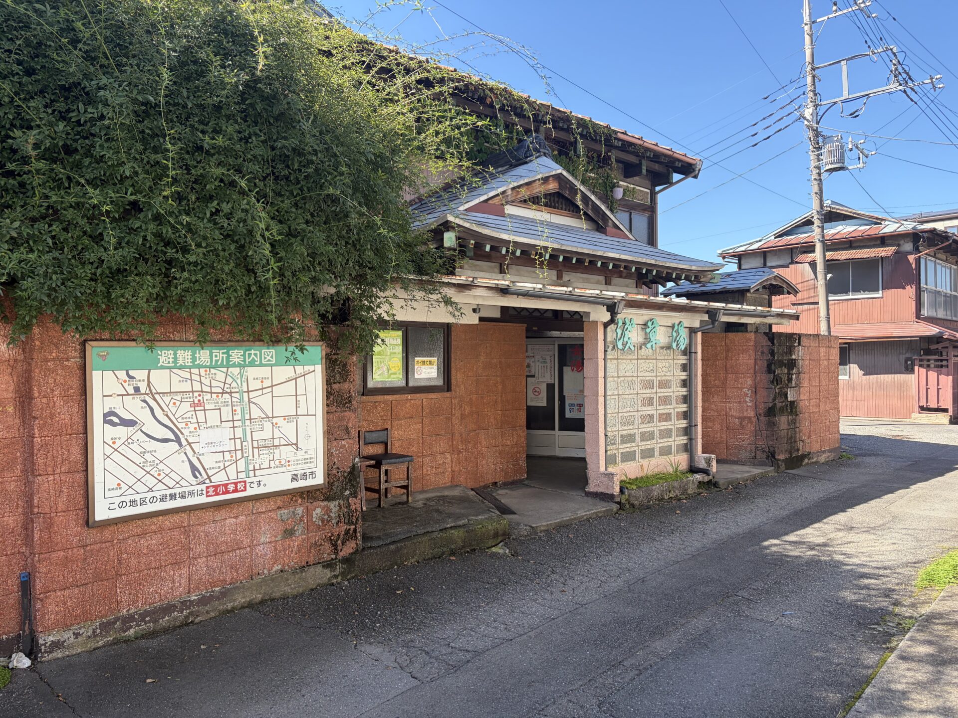路地から見た浅草湯。ツタに覆われた2階建てと、社寺風の屋根の玄関
