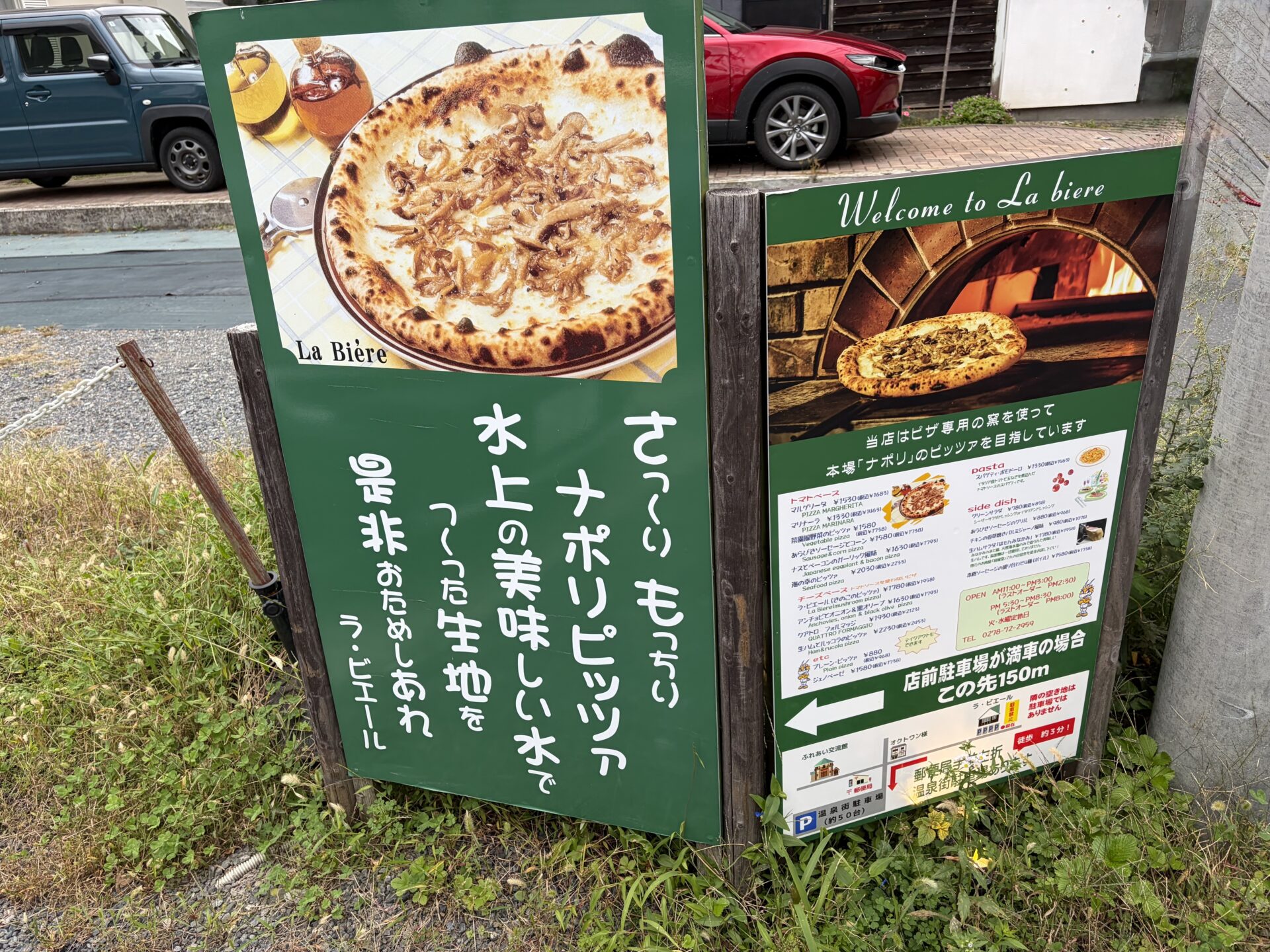 道ばたの看板。左に「ラ・ビエール」の写真、右にメニューと営業時間、温泉街駐車場への地図