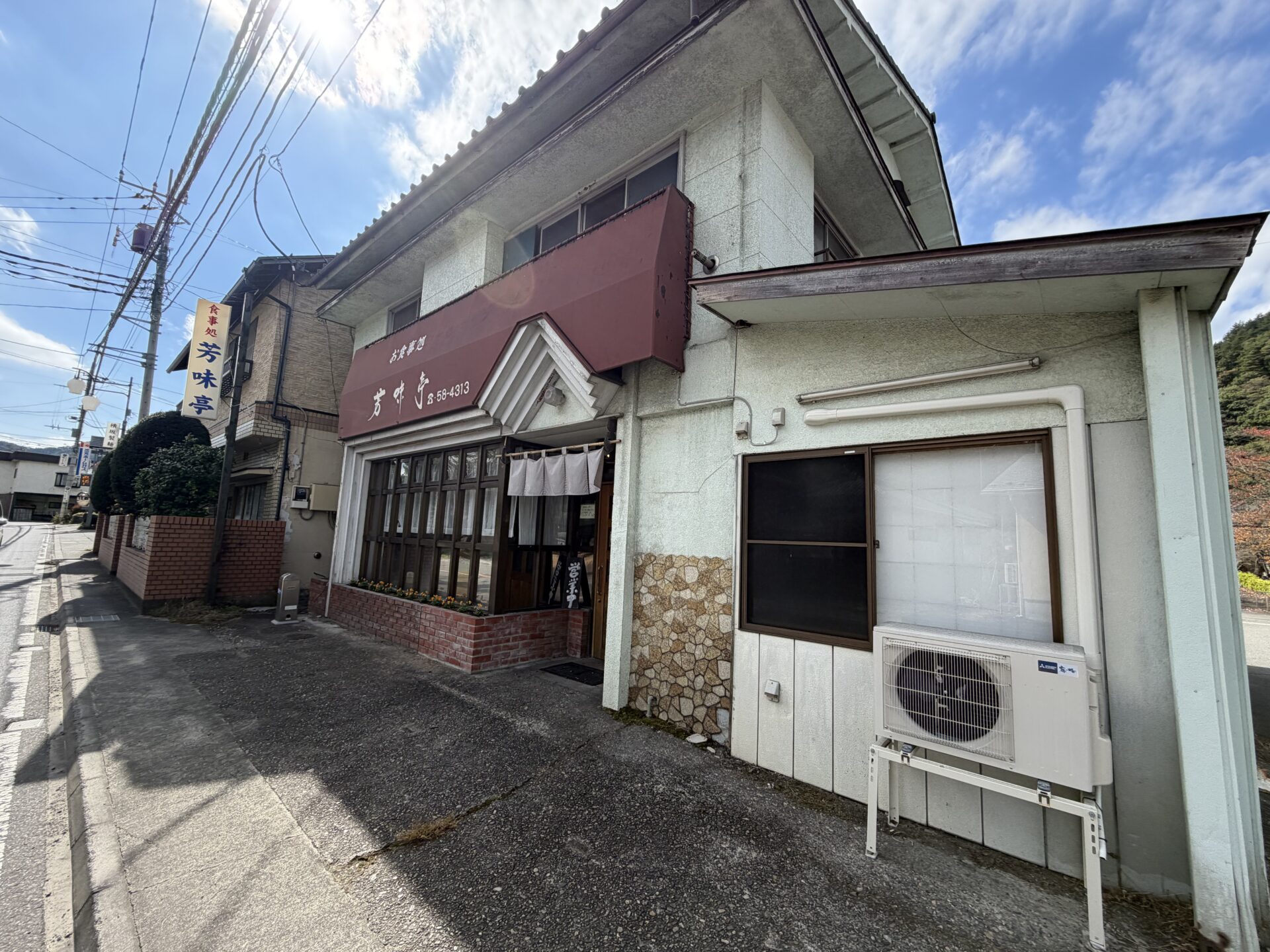 芳味亭の外観。赤茶色のテントが目印