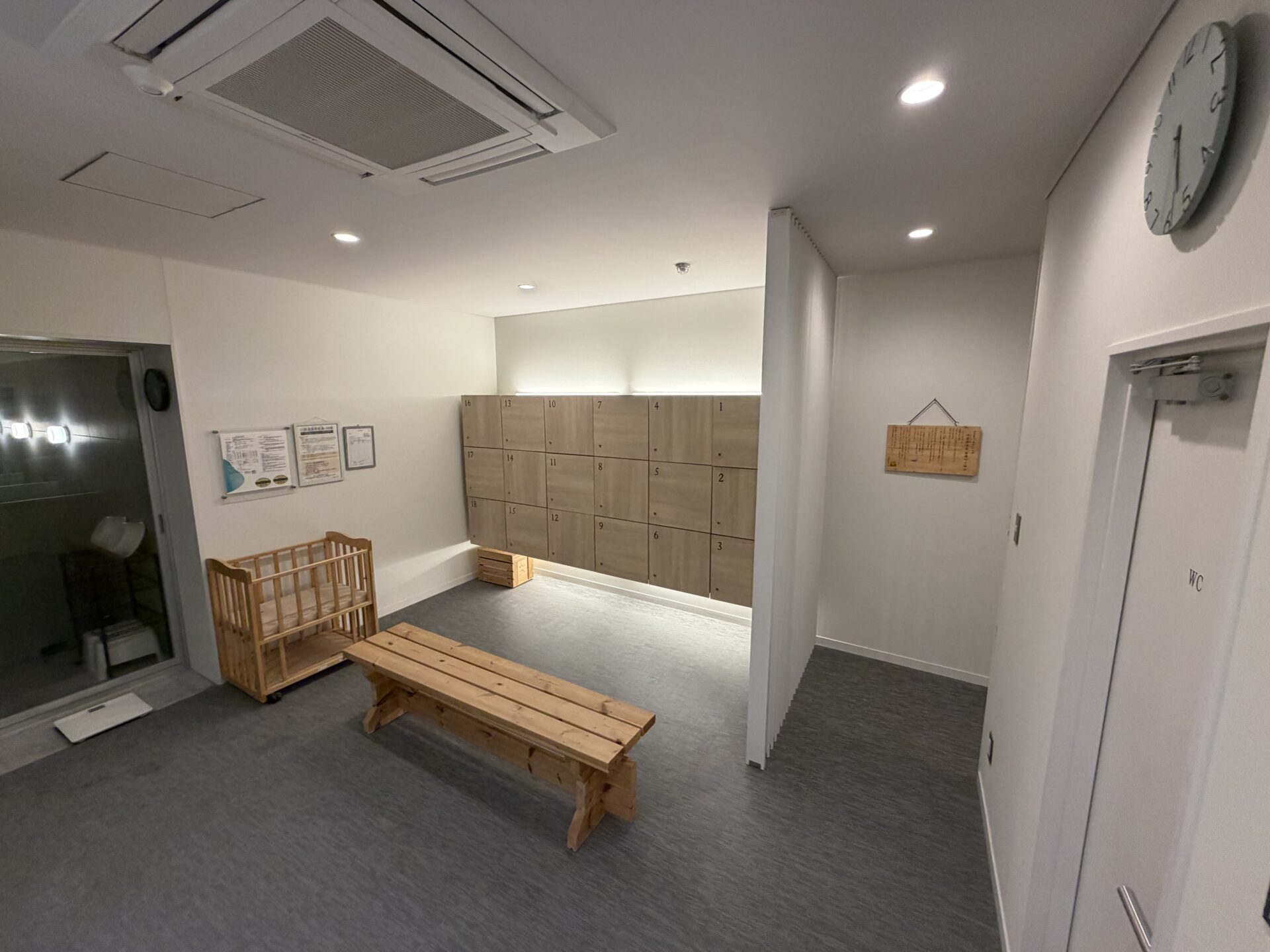 川原湯温泉 笹湯 脱衣所。鍵付きロッカーが18個、木のベンチ、ベビーベッドと体重計
