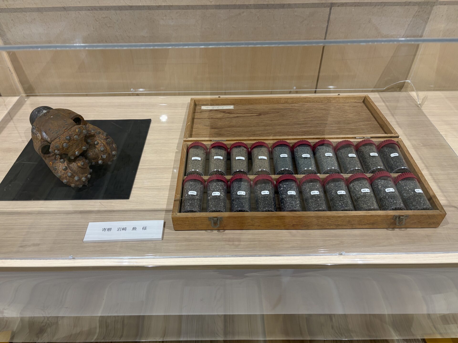 湯〜トピアみどモスパ ロビーに展示された掘削機のドリルビットと掘削土の標本ケース