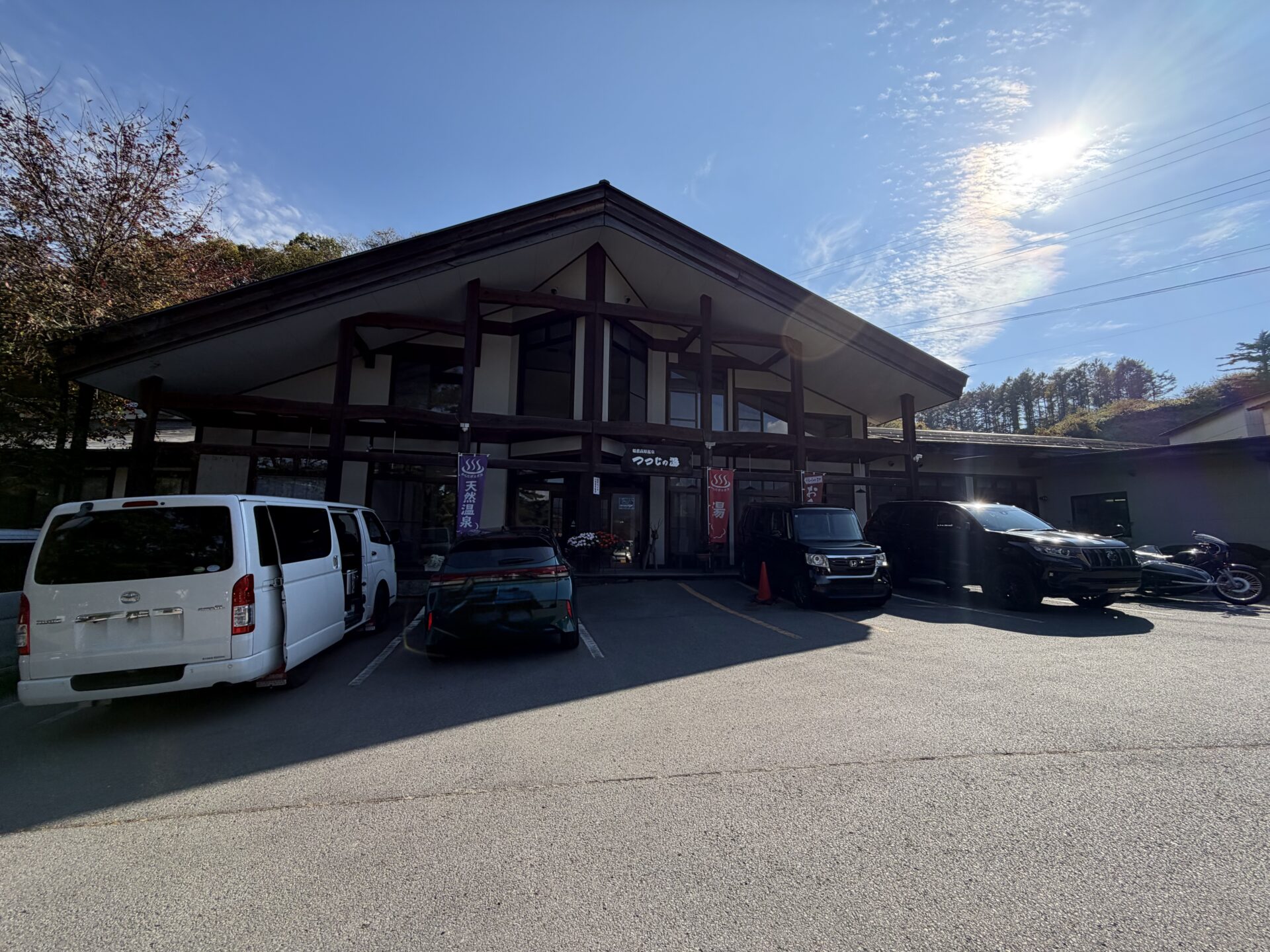 嬬恋高原温泉つつじの湯の外観。大きな屋根と駐車場、月曜祝日の14時すぎ