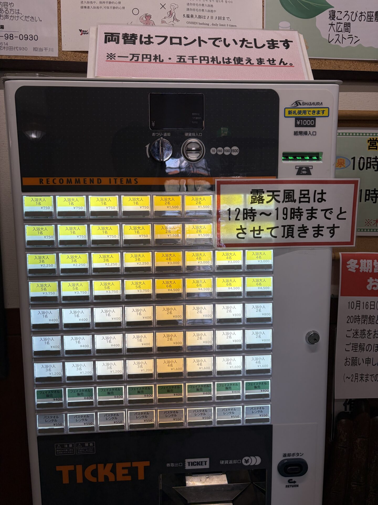 嬬恋高原温泉つつじの湯 入口の券売機。大人750円・小人400円、上に「両替はフロントで」「露天風呂は12時〜19時まで」の張り紙